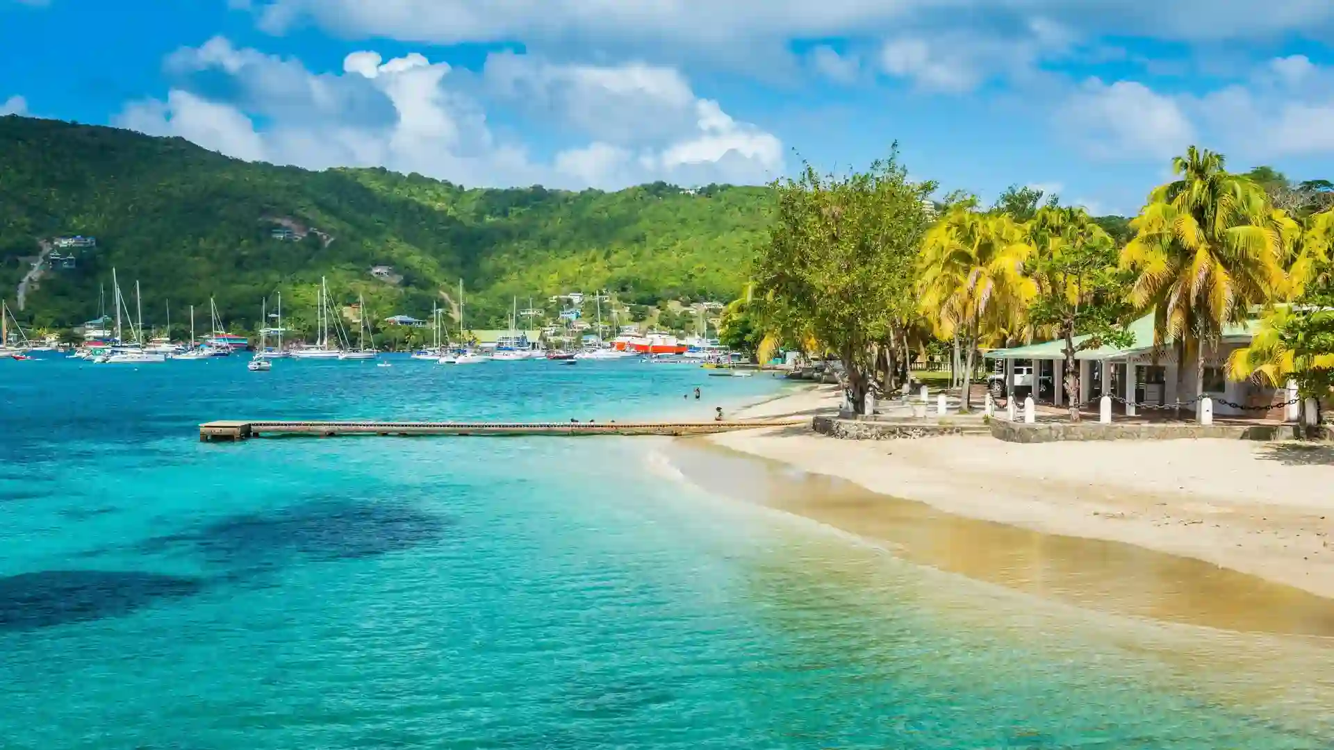 Sailboats anchored in Admiralty Bay with the colorful waterfront of Port Elizabeth, Bequia