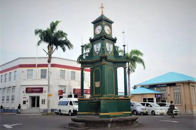 Green Victorian clock tower at the Circus in Basseterre, Saint Kitts, surrounded by historic buildings