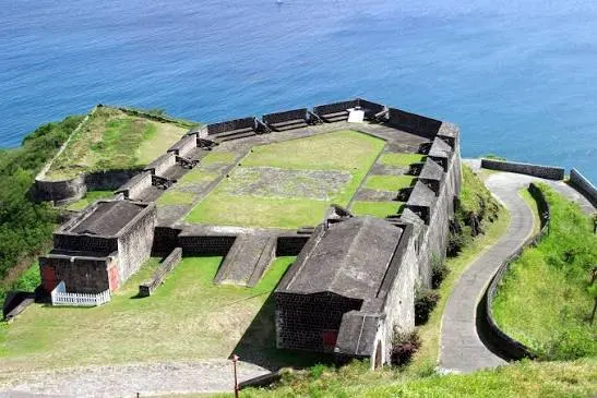 Stone walls and bastions of Brimstone Hill Fortress on a green hilltop overlooking the Caribbean Sea, Saint Kitts