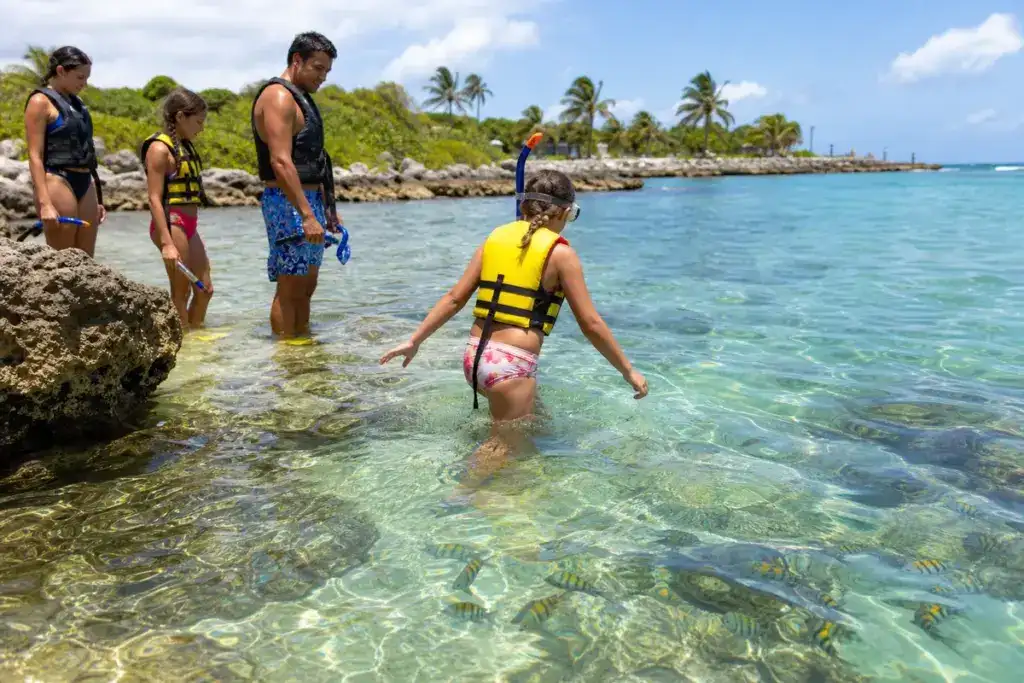 Snorkelers entering clear water from a dock at Chankanaab Park, Cozumel
