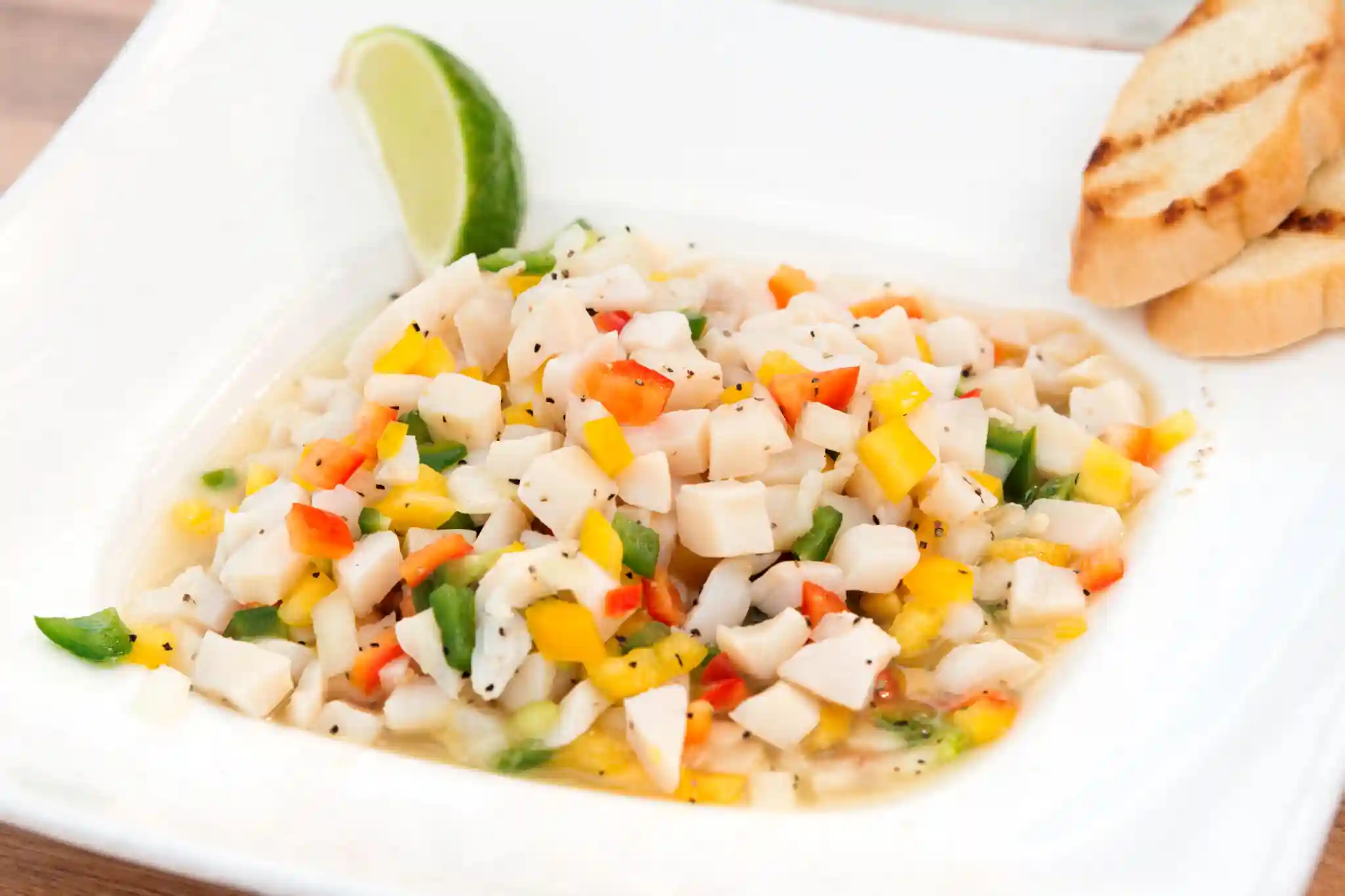 Bowl of fresh conch salad with peppers, onions and lime at a beach shack in Blue Hills, Providenciales