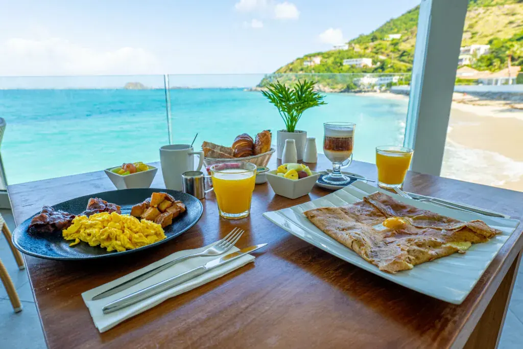 Waterfront restaurant tables lit at sunset along the beach in Grand Case, Saint Martin