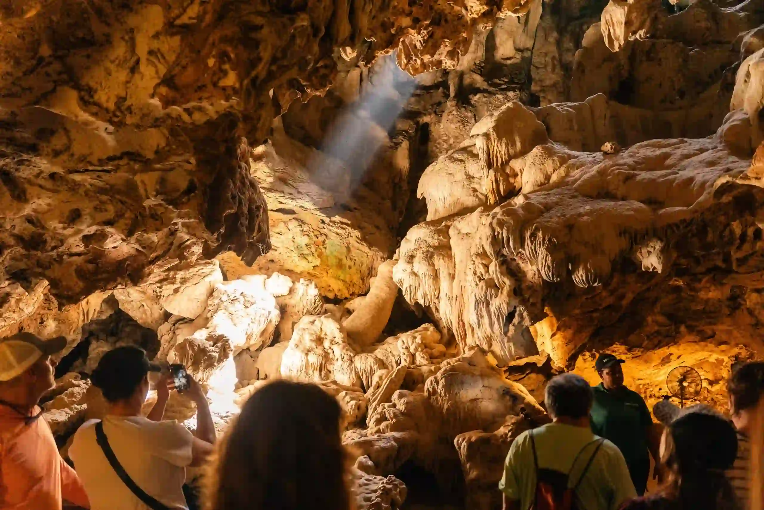 Stalactites and stalagmites lit inside the limestone chambers of Hato Caves, Curacao