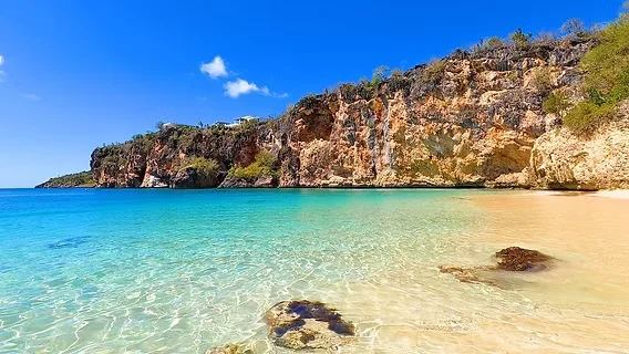 Small secluded beach at Little Bay, Anguilla, surrounded by tall limestone cliffs