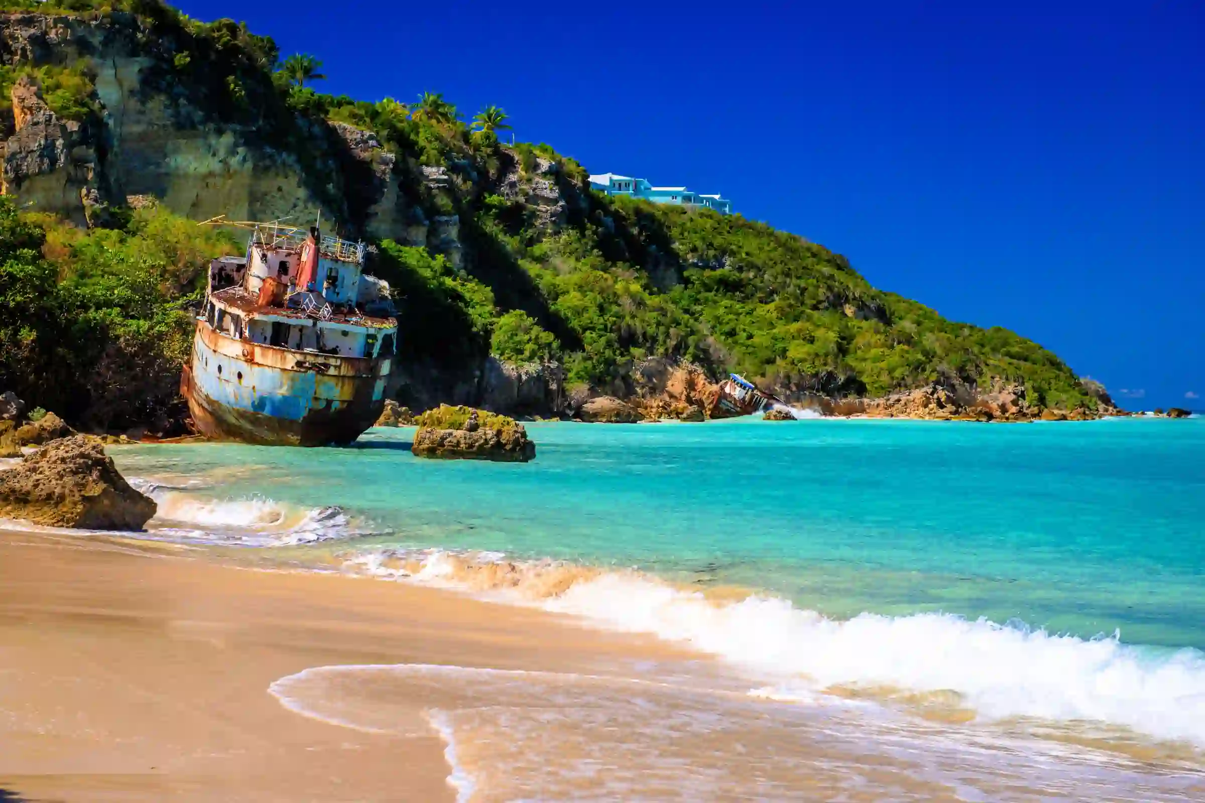 Sailboats anchored in Road Bay at Sandy Ground, Anguilla, with beach bars along the shore