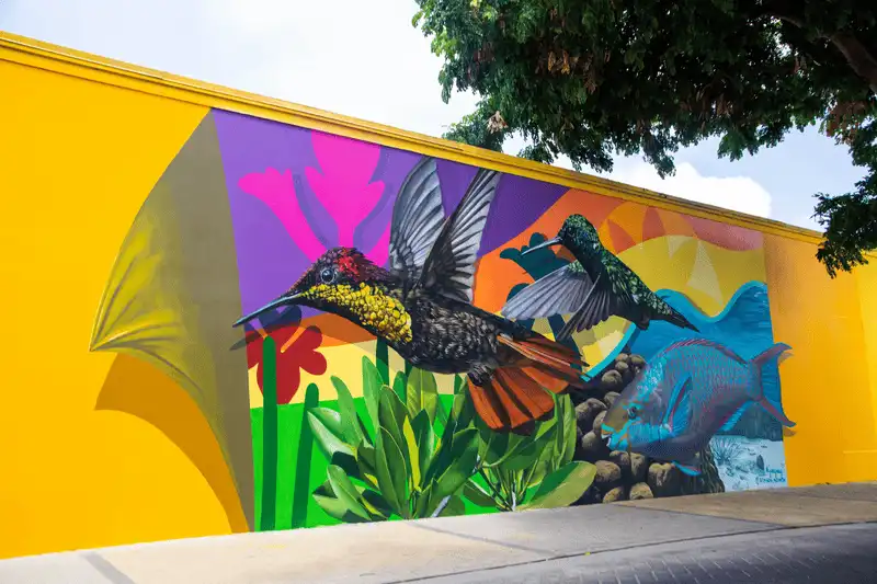 Large colorful mural painted on a building wall in San Nicolas, Aruba