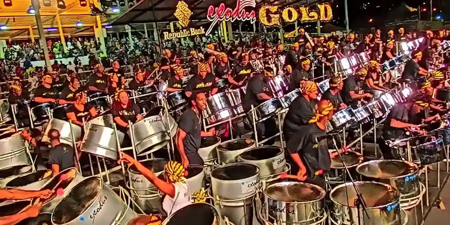 Steelband musicians practicing on rows of steel pans at a pan yard in Port of Spain, Trinidad