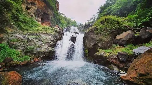 Three waterfalls pouring into a deep pool in a steep rainforest gorge at Trinity Falls, Saint Vincent