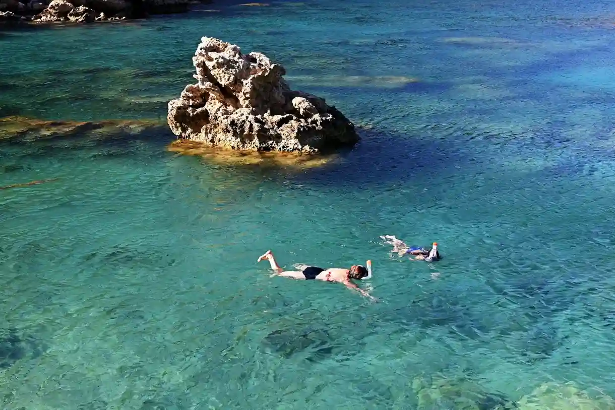 White sand beach and turquoise water at Trunk Bay, St. John, with the small cay offshore where the snorkel trail runs