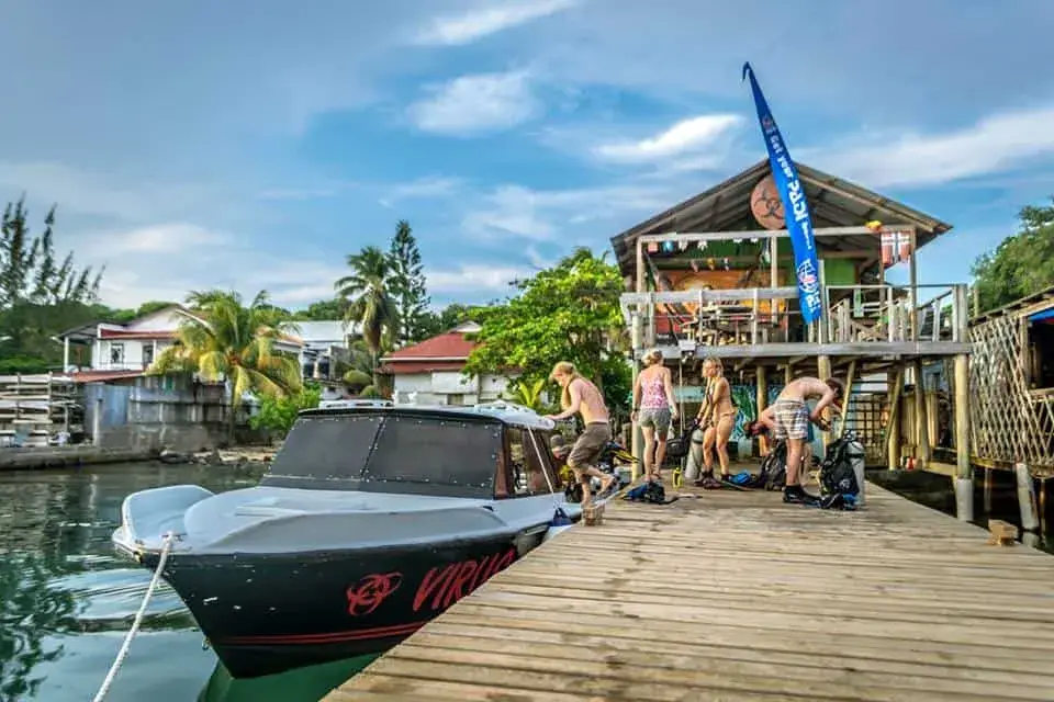 Colorful wooden buildings and dive shop docks along the waterfront of Utila Town, Bay Islands, Honduras