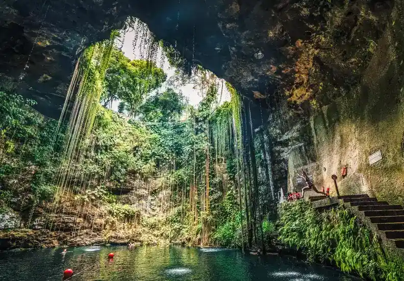 Clear blue water inside a cave cenote with limestone formations on the Riviera Maya